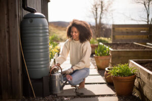 young woman using a rain barrel