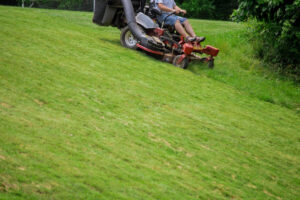 person going down a hill on a zero turn mower